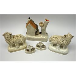 A pair of 19th century Staffordshire figures modelled as Sheep, H10.5cm, together with a pair of miniature groups, each modelled as two sheep stood before a tree, H5.5cm, and a later Staffordshire style pen holder. (5). 