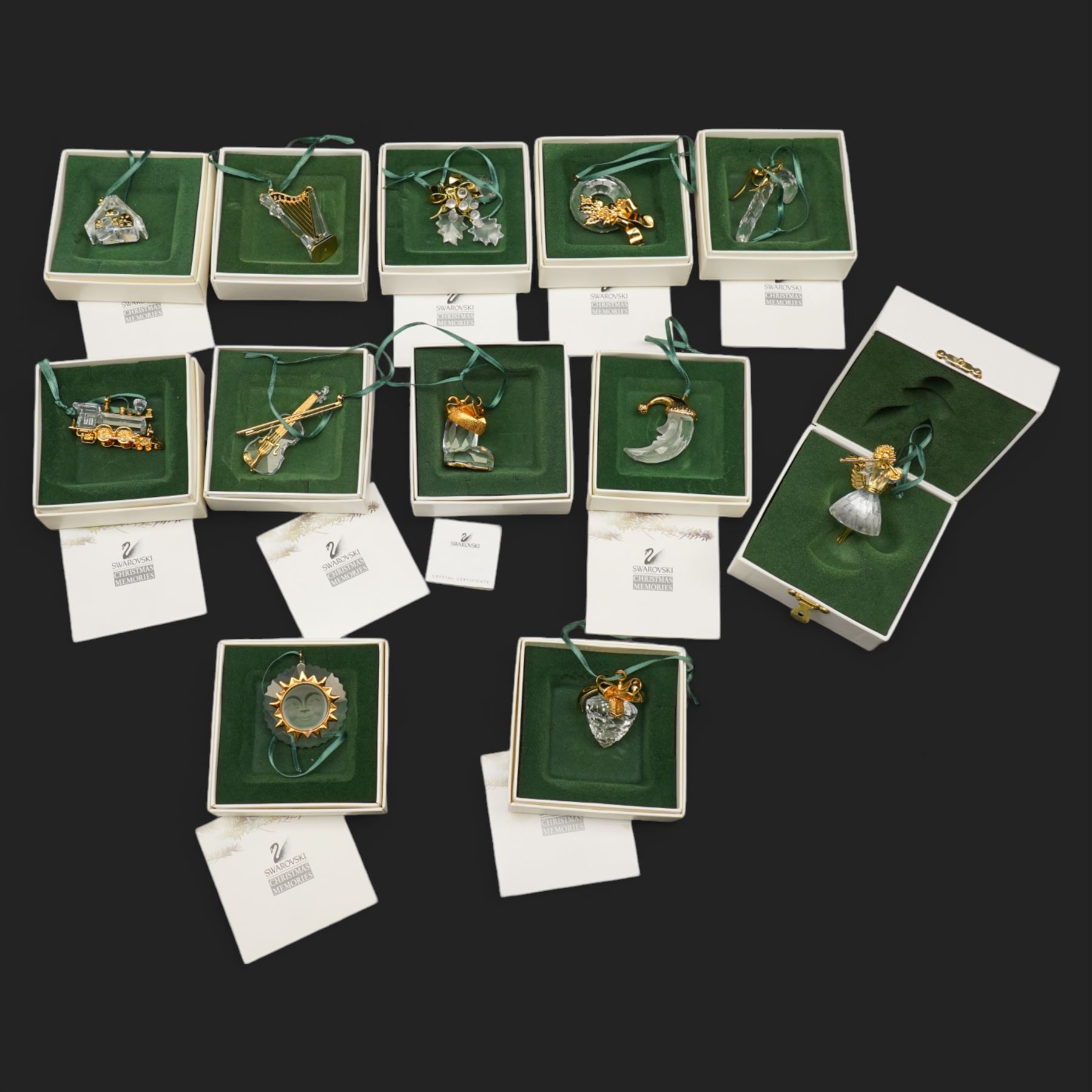Twelve Swarovski crystal 'Christmas' and 'Crystal' Memories ornaments, comprising Moon, Sun, Boot, Candy Cane, Christmas Wreath, Pinecone and Holly etc, boxed and with sleeves (12)