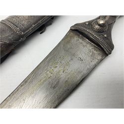Late 19th/20th century Middle Eastern jambiya dagger the 36cm broad curved double edged steel blade with traces of script, horn and copper backed waisted white metal hilt with three roundel buttons; in ornate white metal and leather mounted brass and steel scabbard L60.5cm overall