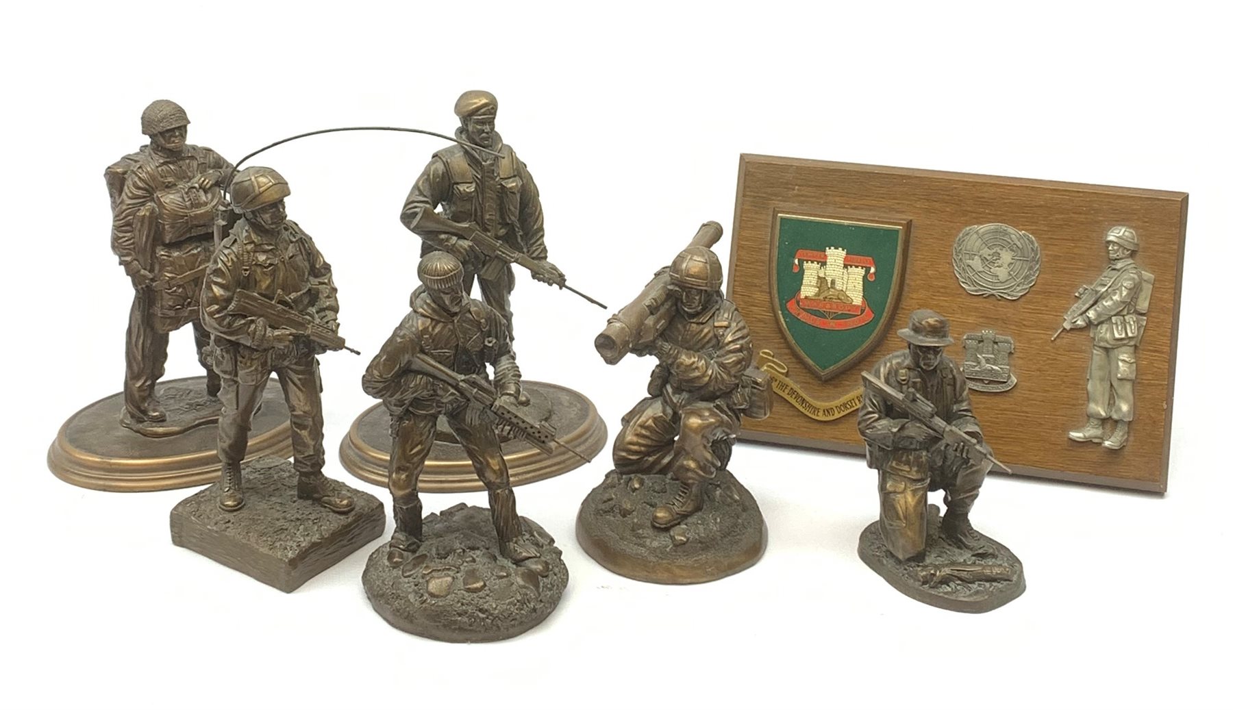 Six Phoenix World Reproductions bronzed figures of soldiers including Special Operations, Law firer, Jungle, radio carrier, Airborne etc, tallest H24cm; and oak Regimental plaque for 1st Bn The Devonshire and Dorset Regiment with strut support (7)