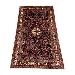 Persian Nahawand blue ground rug, the field with trailing branch and central medallion, decorated with stylised flower head, animal and bird motifs, the repeating three band border with floral panels