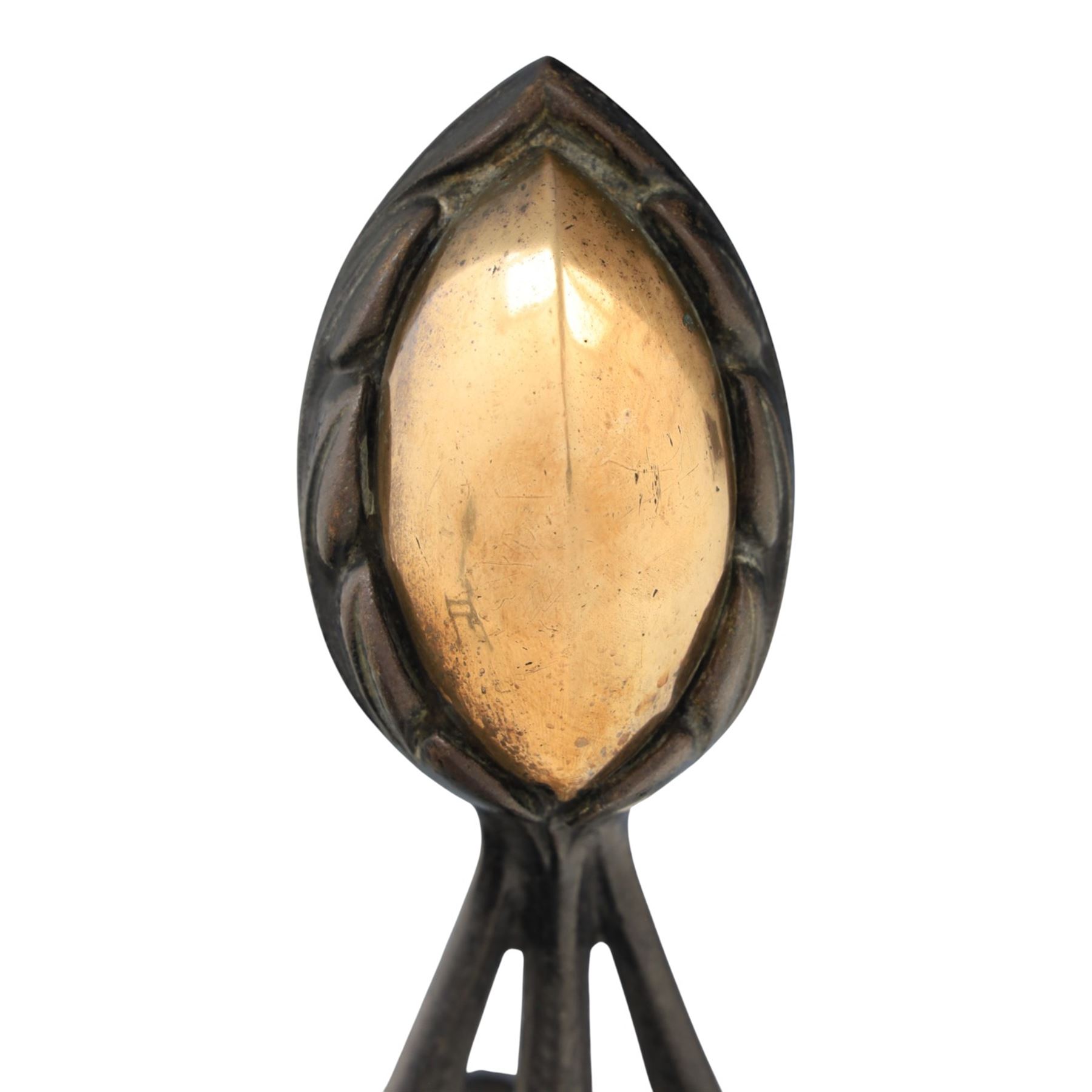 Arts and Crafts cast iron and brass andirons, brass and copper acorn finials above openwork uprights, raised on shaped arched feet with hammered detail