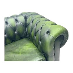 Two seat Chesterfield design sofa bed, upholstered in emerald green leather with deep-buttoned detailing, rolled arms, two loose seat cushions, and pull-out 