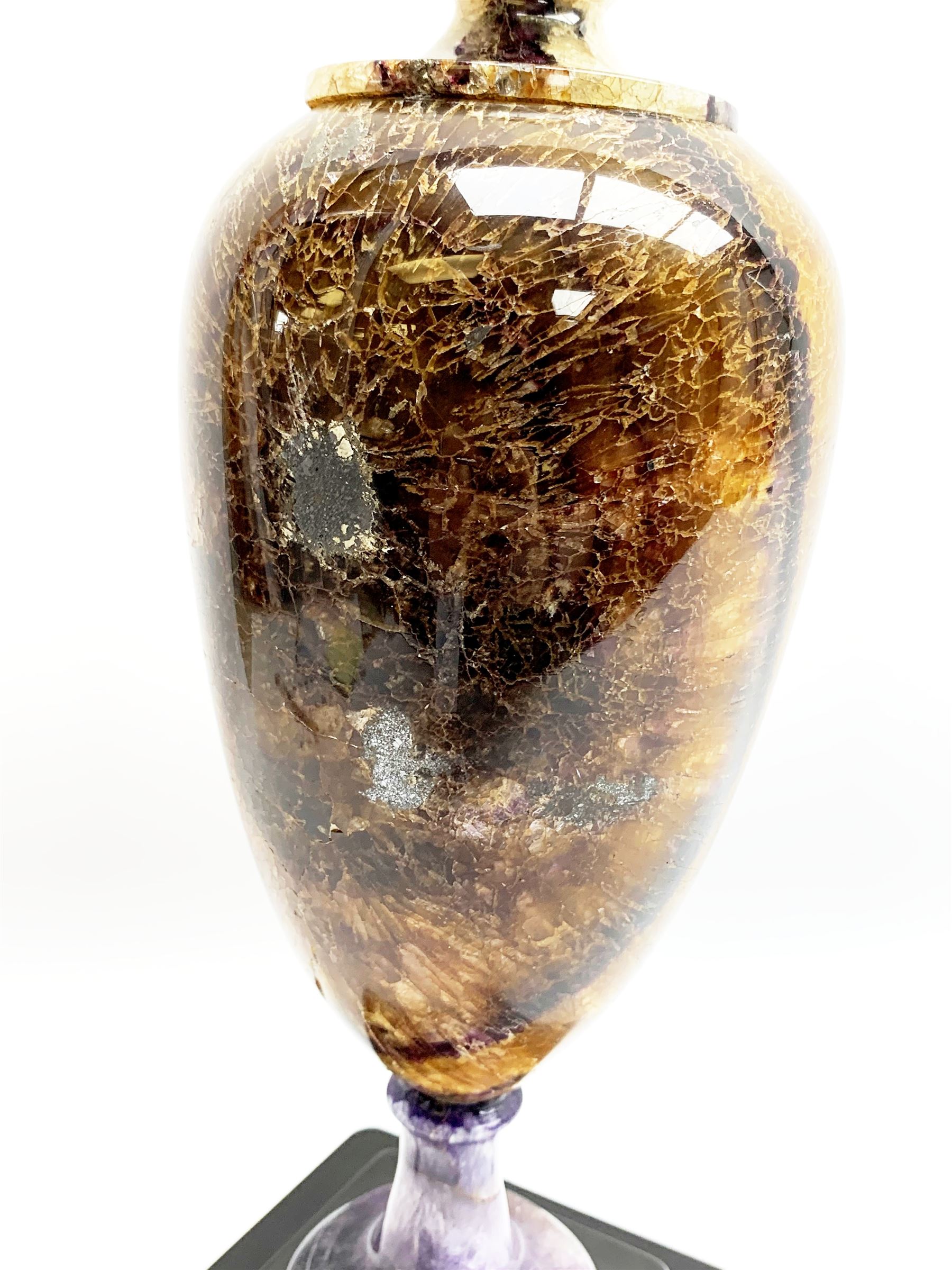 Early 19th century and later Blue John urn, Winnats one vein, of ovoid form with integrated cover and ball finial, upon a spreading circular base, and square stepped black lacquered base, H34.5cm