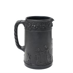 Four pieces of 19th century Wedgwood black basalt ware, c.1875, comprising larger and smaller jug, covered sucrier and teapot, each decorated with classical scenes in high relief, larger jug H13cm