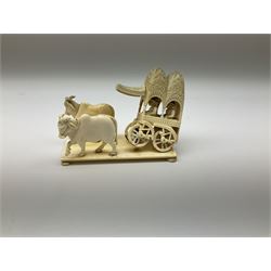 Carved ivory figure group, modelled as a foliate detailed carriage containing passengers and driver, drawn by two oxen, raised upon a rectangular base with bun feet L13cm, H11cm and two Japanese ivory netsukes