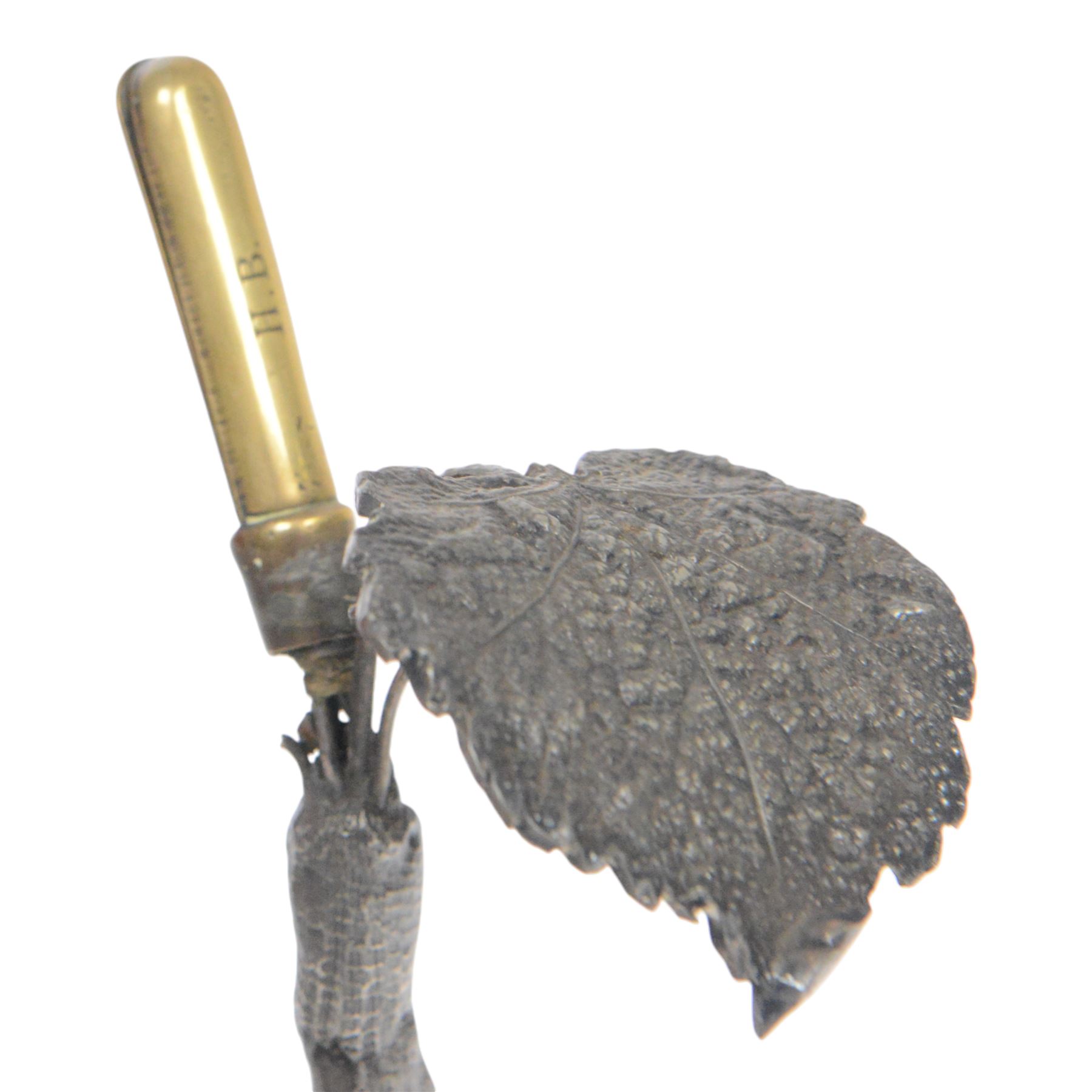 19th century silver plated desk holder, the circular naturalistically modelled base cast with fruiting vines and with applied figure of a ram, rising to a vine with two leaves, and initialled brass clip, H18cm