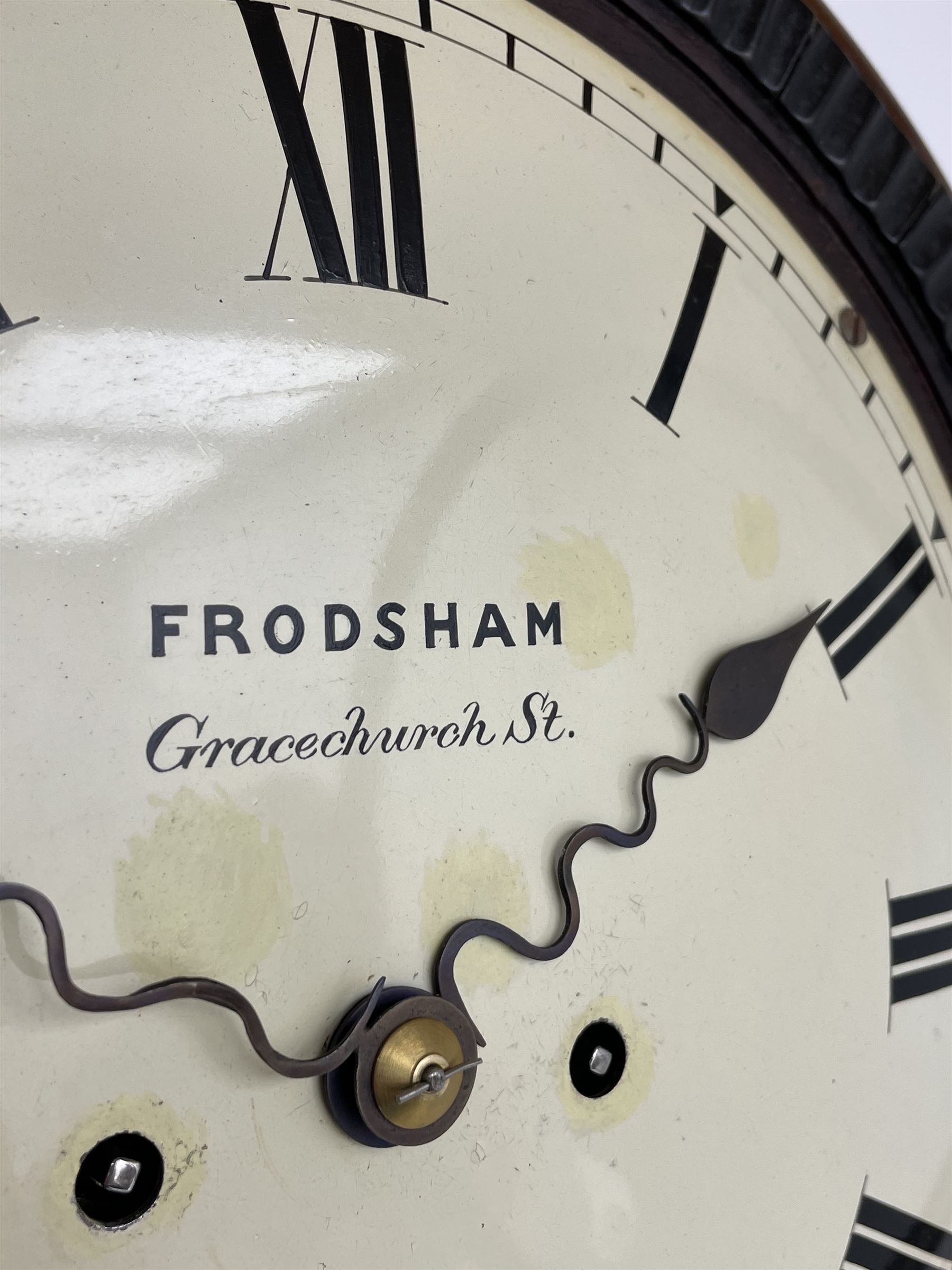 Frodsham of London - 8-day chain driven twin fusee wall clock in a mahogany case c1870, veneered case inlaid with brass stringing and motifs, shaped earpieces and chisel shaped base with pendulum adjustment door, 10” painted steel dial with Roman numerals, minute track and blued serpentine steel hands, dial inscribed Frodsham, Gracechurch Street, London, chain fusee, five-pillar, rack striking movement striking the hours on a cast bell. With pendulum.
H65 W34 D18
George Edward Frodsham, son of John Frodsham is recorded as working in Gracechurch Street, London 1869-79. Succeeded to Frodsham & Baker

