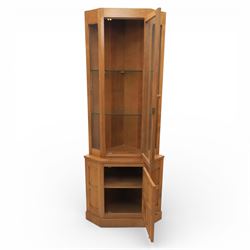 Cat & Mouseman - oak corner cabinet, glazed door with two fixed glass shelves, above a panelled door and sides raised on a plinth base, with cat and mouse carving to the lower side by Lyndon Hammell a former apprentice of Robert 'Mouseman' Thompson