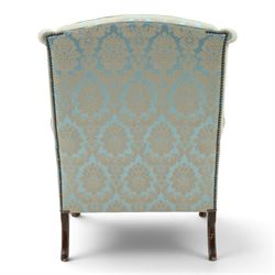 Georgian design carved mahogany framed wingback armchair, high wingback over sprung seat and loose cushion with rolled arms, upholstered in cyan ground gilt foliate damask fabric, on shell-carved cabriole supports with pad feet