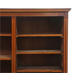 Quality Edwardian inlaid mahogany triple-column open bookcase, projecting cornice over a satinwood banded frieze, fitted with fourteen adjustable shelves with strung facias, the shaped apron on bracket feet