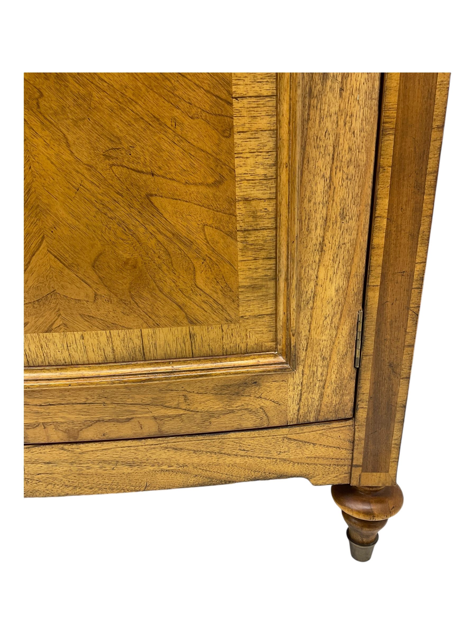 Frank Hudson - mid-20th century Mindi ash and burr walnut double wardrobe, moulded rectangular cornice over two panelled doors with chevron pattern veneers, raised on turned supports
