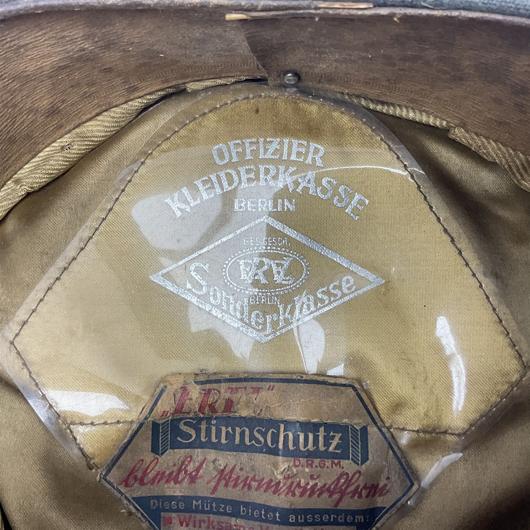 WW2 German Infantry Officer's visor cap with cloth insignia; labelled and stamped Offizier Kleiderkasse Berlin and Erel Stirnschutz
