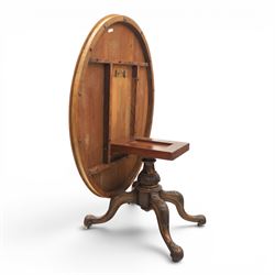 Victorian figured walnut oval loo tilt top table, raised on a heavily carved quatriform base with scrolled supports, terminating in castors