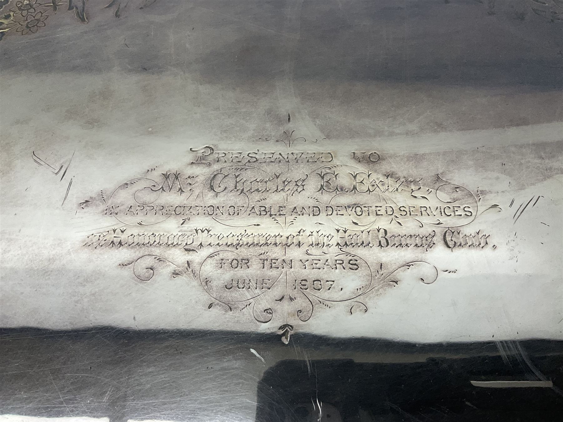 Oval silver plate twin handled tray, egg and dart edge, engraved with floral springs surrounding an central inscription, L65cm