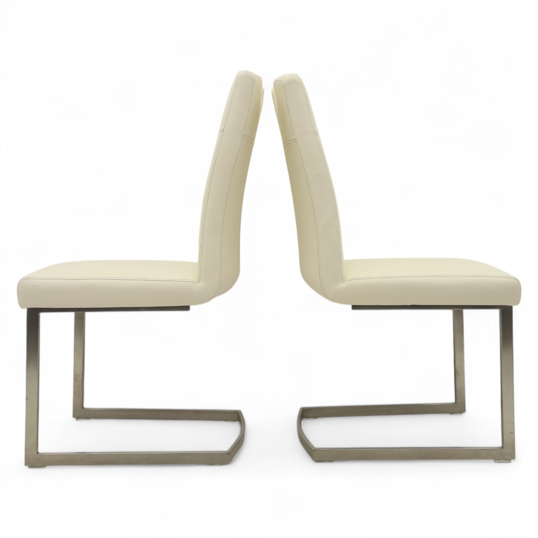 Set of seven contemporary style dining chairs, each with a high padded back and seat upholstered in faux leather on brushed steel sled bases  