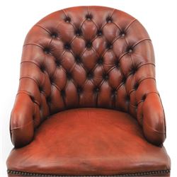 Victorian style oxblood leather armchair, deep button upholstered back and sides with rolled arms and brass studded borders, on turned front legs with brass and ceramic castors and splayed rear supports