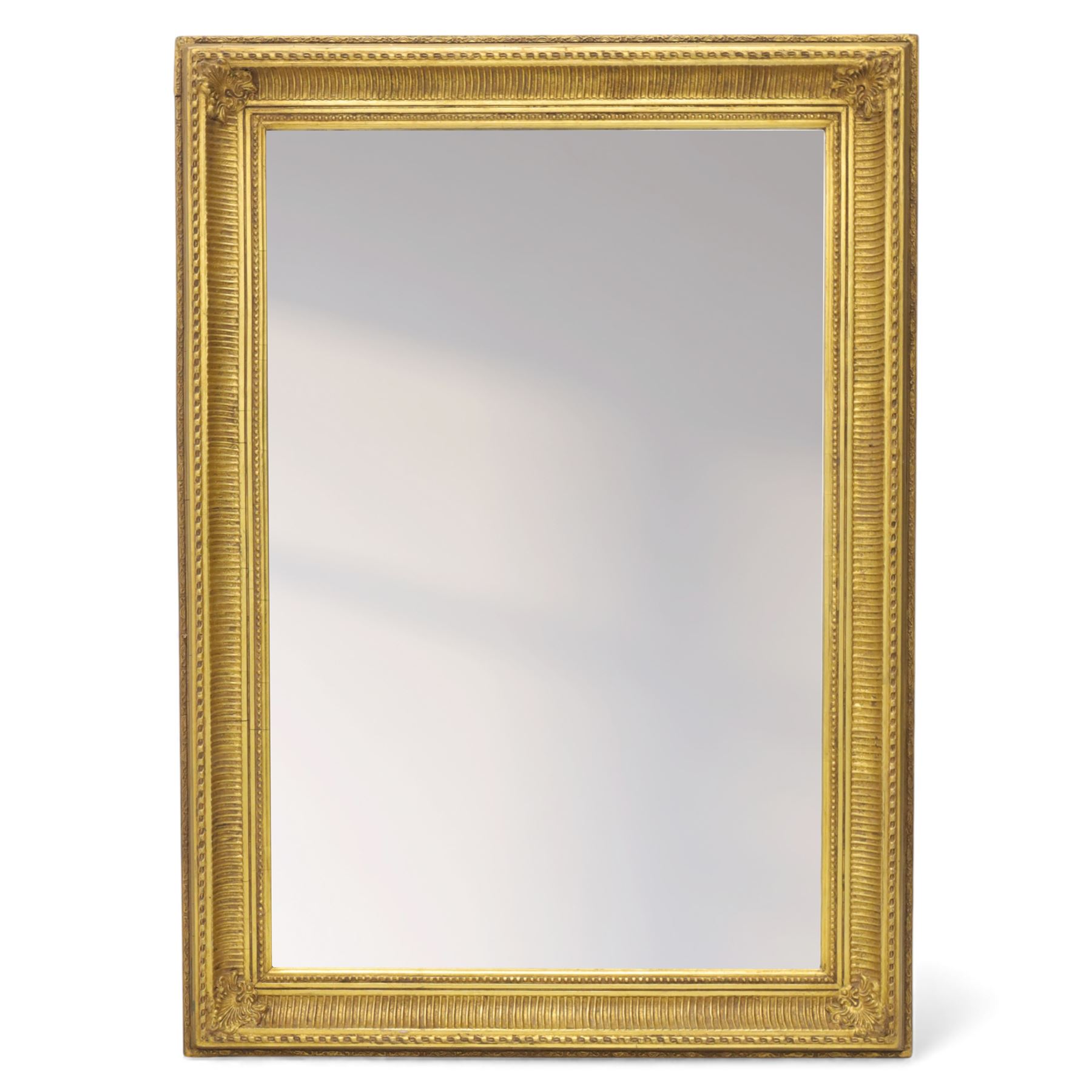 Two late 20th century gilt mirrors, foliate and dart detailing to the frame (H 92cm, W 66cm; H 53cm W 45cm)