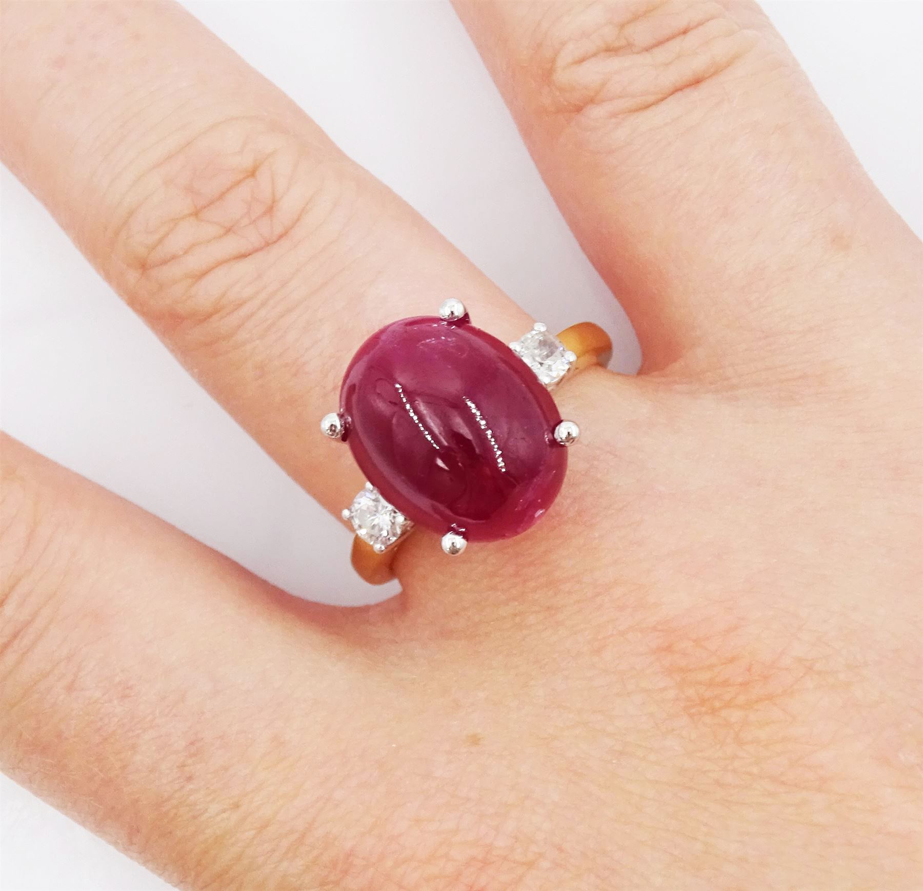 18ct gold ruby and diamond three stone ring, oval cabochon cut ruby of approx 11.40 carat, with a single round brilliant cut diamond set either side, hallmarked