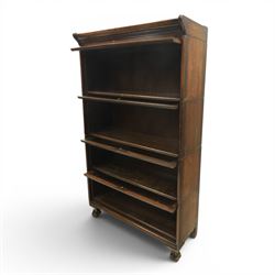 Harris Lebus - oak barrister stacking bookcase, four tier design with glazed fronts with brass knobs, raised on claw and ball feet