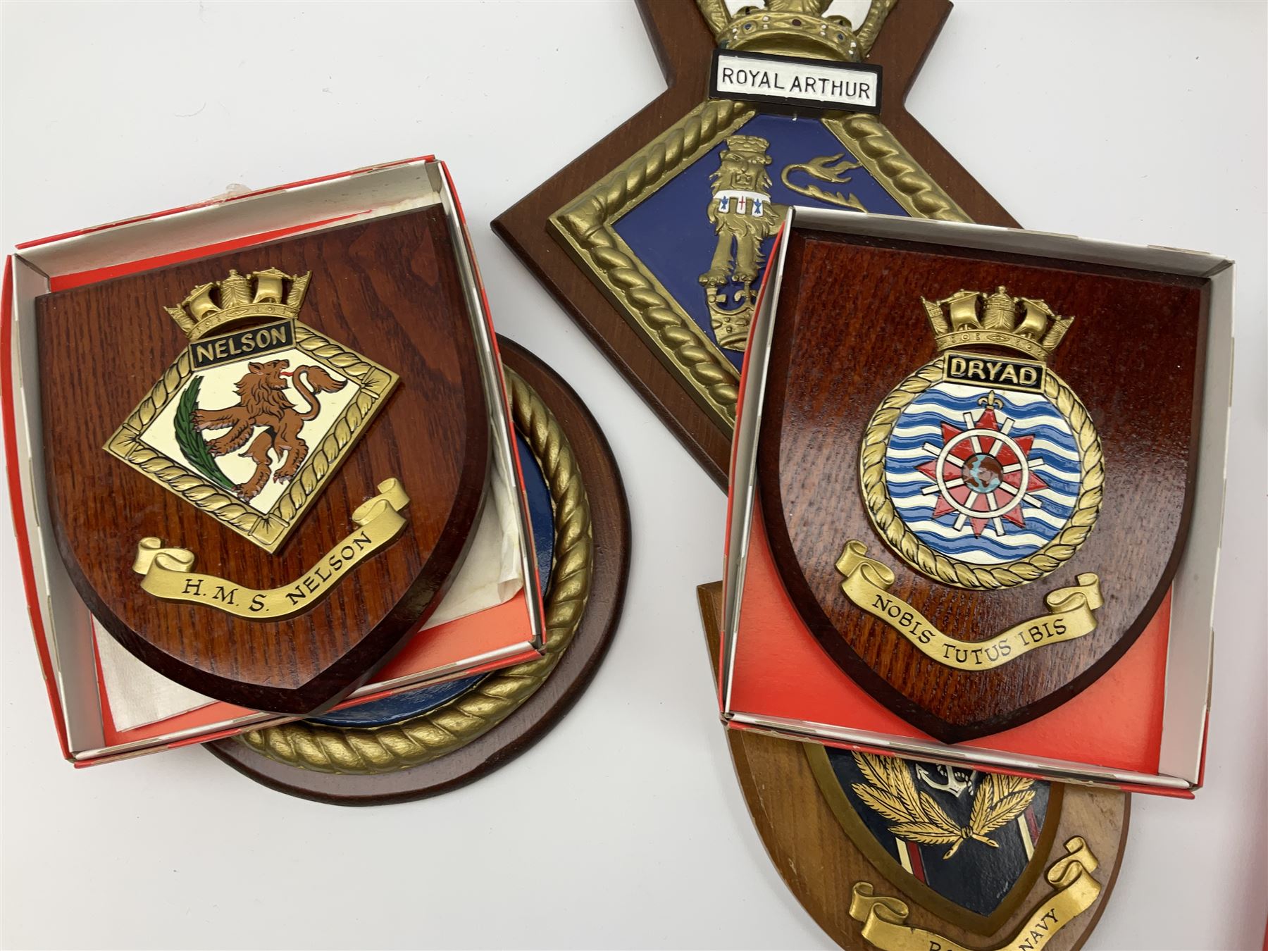 Various Navy wooden heraldic shields each with hand painted raised shield, including HMS Indefatigable, HMS Nelson,  HMS Victory etc, ten in total.  