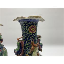 Pair of 19th century clobbered Chinese Export vases, each with lobed rim and applied twin temple lions and dragons to the waisted neck, decorated with enamel panels of traditional scenes of figures and buildings, surrounded by blossoming flowers, H20cm