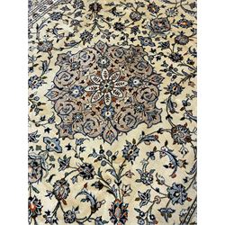 Persian Kashan ivory ground carpet, decorated all-over with interlacing foliate and stylised plant motifs, central scrolling medallion and matching spandrels, the guarded border decorated with repeating palmettes