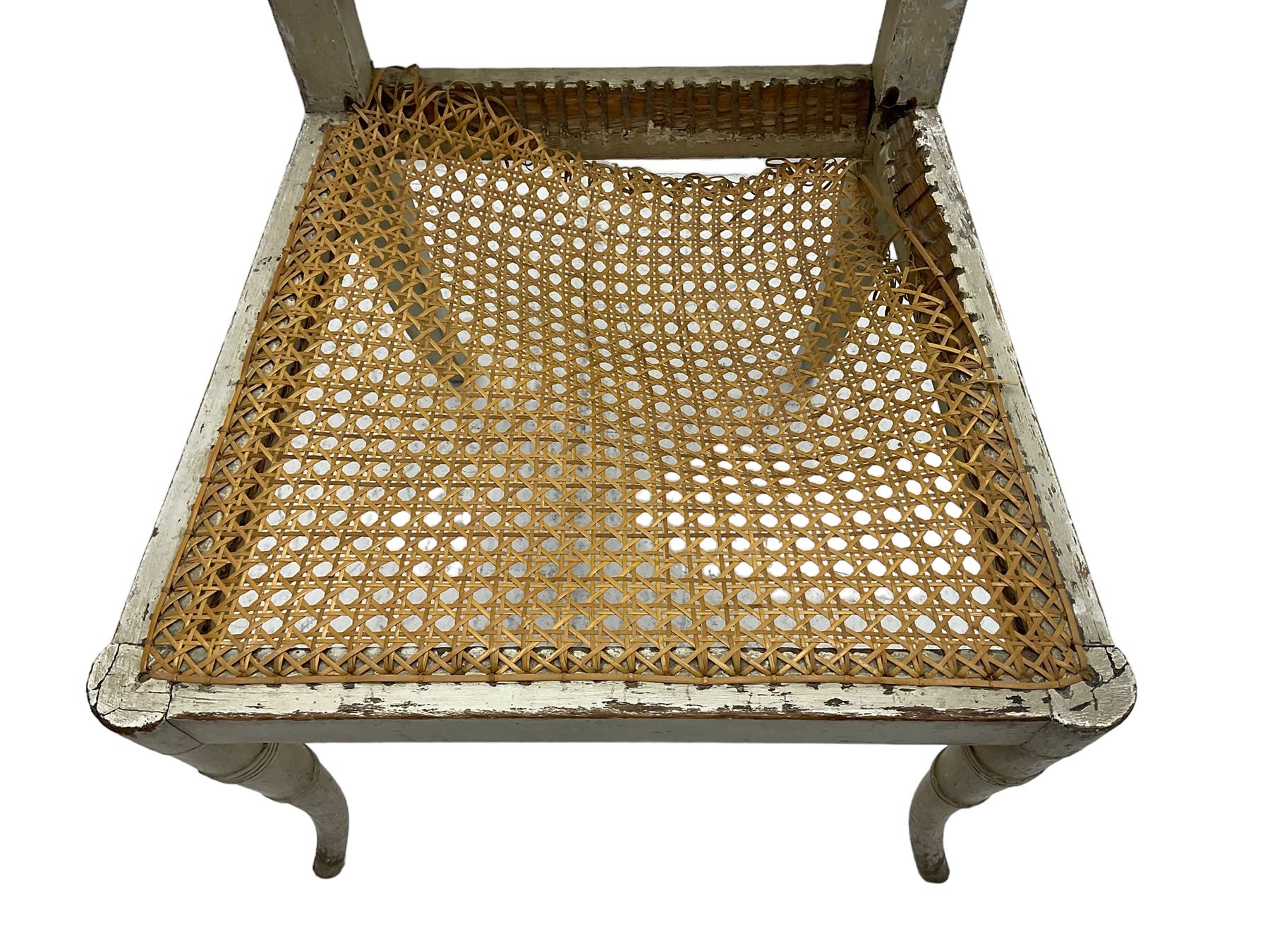 Collection of Regency dining chairs - set of four Regency painted beech dining chairs, with cane seat and back, on collar turned supports with splayed feet (W46cm, H84cm); a pair of Regency ebonised dining chairs (W47cm, H77cm); and a single Regency dining chair, the cresting rail painted with floral cornucopias and central putto vignette, X-frame back over cane seat, on collar turned front supports painted with foliage (W46cm, H84cm) (7)