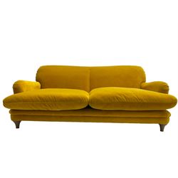 Loaf - large two seat 'Jonesy' sofa, upholstered in mustard velvet fabric with sprung back and loose seat cushions, raised on pale oak turned supports