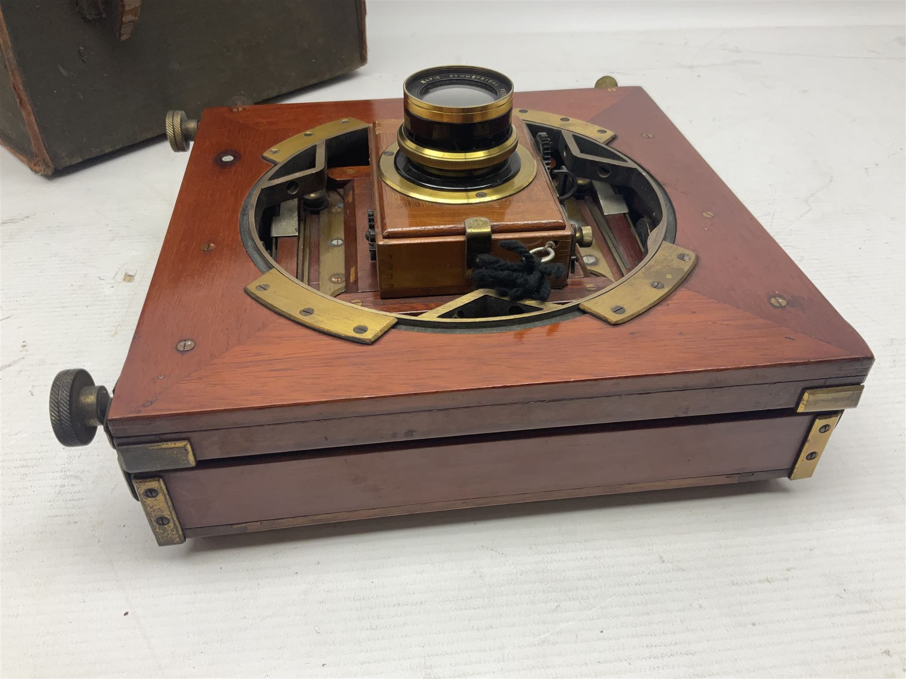 Folding plate camera in mahogany and lacquered brass, with Rapid Symmetrical Reetigmat len and two dark slides in canvas case