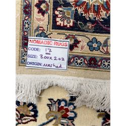 Northeastern Persian Meshed hand-knotted rug, ivory ground with an overall design of scrolling vines, palmettes, and rosettes in an indigo palette, soft blues, and madder, framed by a deep indigo border of lotus palmettes and flowerheads between multiple guard borders, 300cm x 202cm