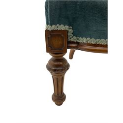 Victorian walnut framed nursing chair, the waisted back with arched cresting rail carved with foliate, buttoned back upholstered in blue fabric, turned and fluted supports with carved decoration 