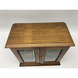 Table top oak smoker's cabinet, the glazed cupboard enclosing two short drawers and shelves, with a hinged lid, H30cm