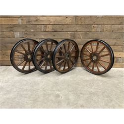 Set of four wheels from an early 20th century cart, wood with metal outer