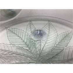 Two French pressed glass bowls of shallow circular form, relief moulded with flowers and foliage, together with a matching charger, largest bowl D34cm  