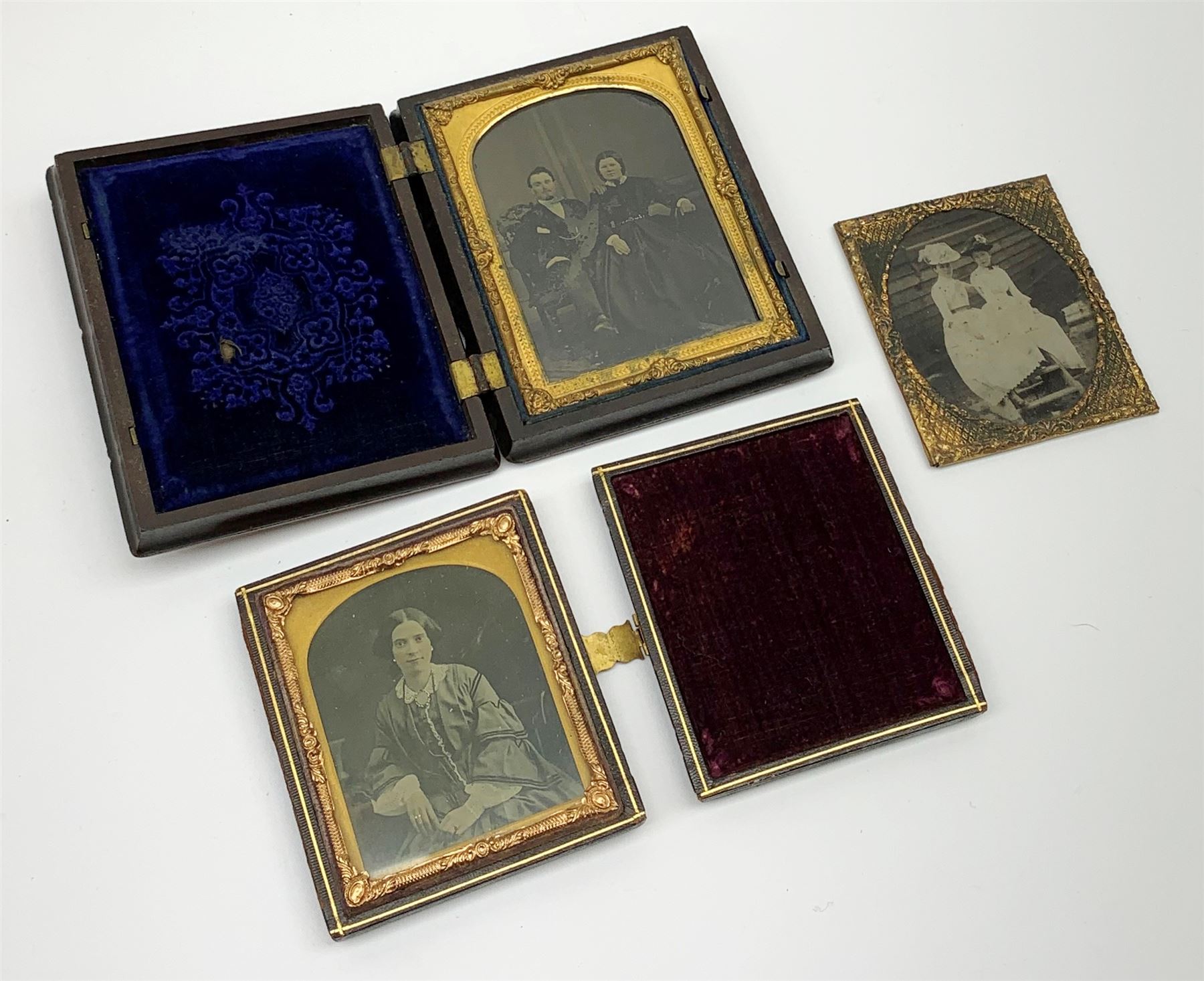 A Victorian ambrotype photograph in gilt surround and Vulcanite type Union case, decorated in low relief to front and verso with a female figure upon horseback, H12.5cm, together with a leather case daguerreotype, and a further loose example. (3).  
