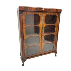 Early 20th century Art Deco walnut and mahogany bookcase, fitted with two astragal glazed doors enclosing three shelves, flanked by column uprights, on cabriole feet 