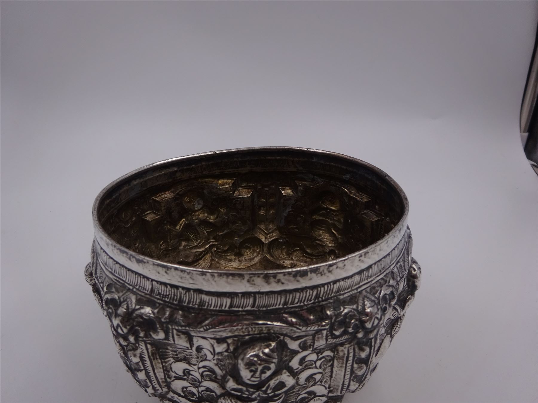 Burmese silver bowl, embossed with figural panels, C scrolls and floral decoration, H8.5cm