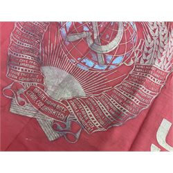 1970s Soviet banner printed in gold on a red ground, roughly translates as 'Transferable Banner - To the winner in the Socialist Competition' and 'Work Study Live by Communism' verso; wreath of wheat ears to either side; tassels on three sides 110 x 155cm