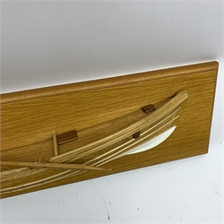 Half block model of a coble made from elm and oak with rudder, loose mounted oar and white painted keel, on oak finish board W63cm