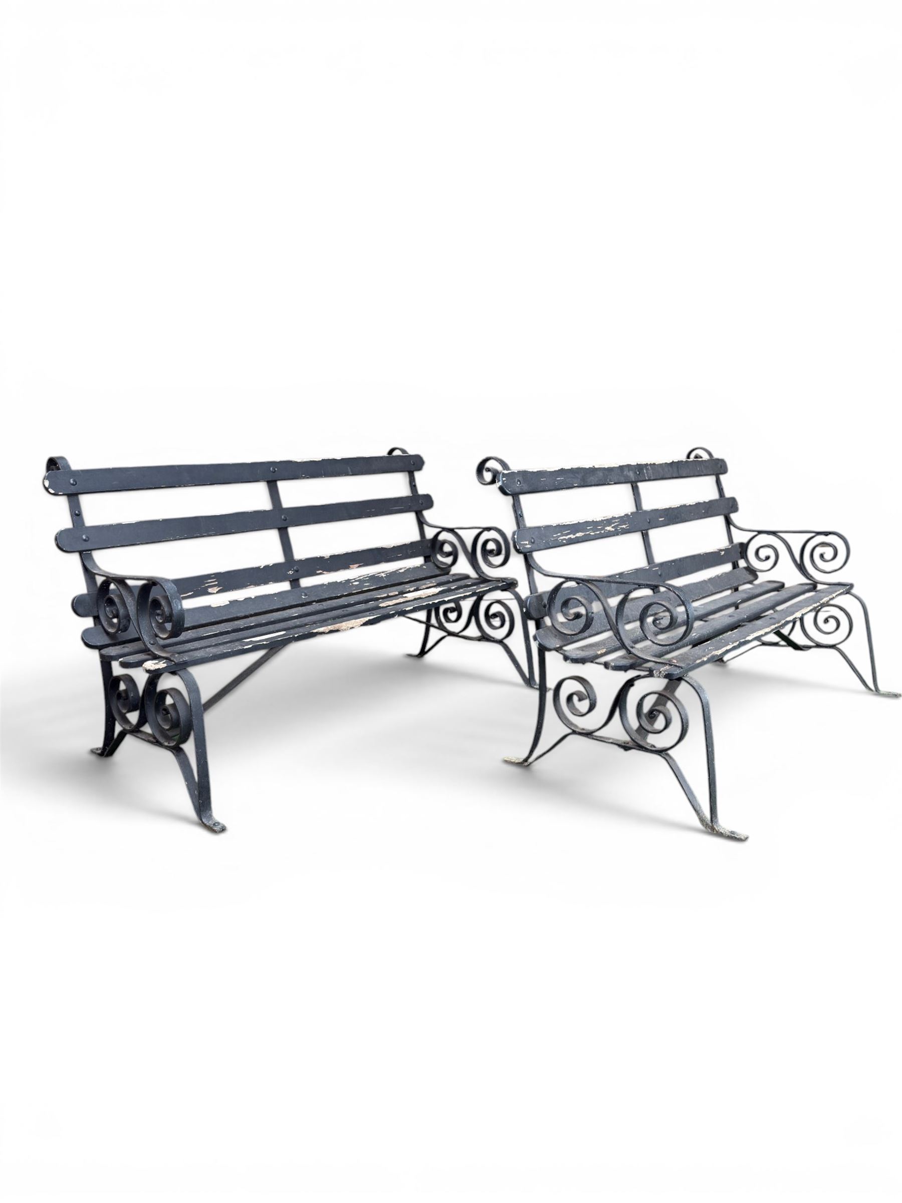 Coalbrookdale - rare pair of wrought iron and slatted wood garden benches, the twin wrought iron strapwork bench-ends formed of four scrolls over splayed feet, number 77 in the Coalbrookdale Castings Catalogue (see illustration)