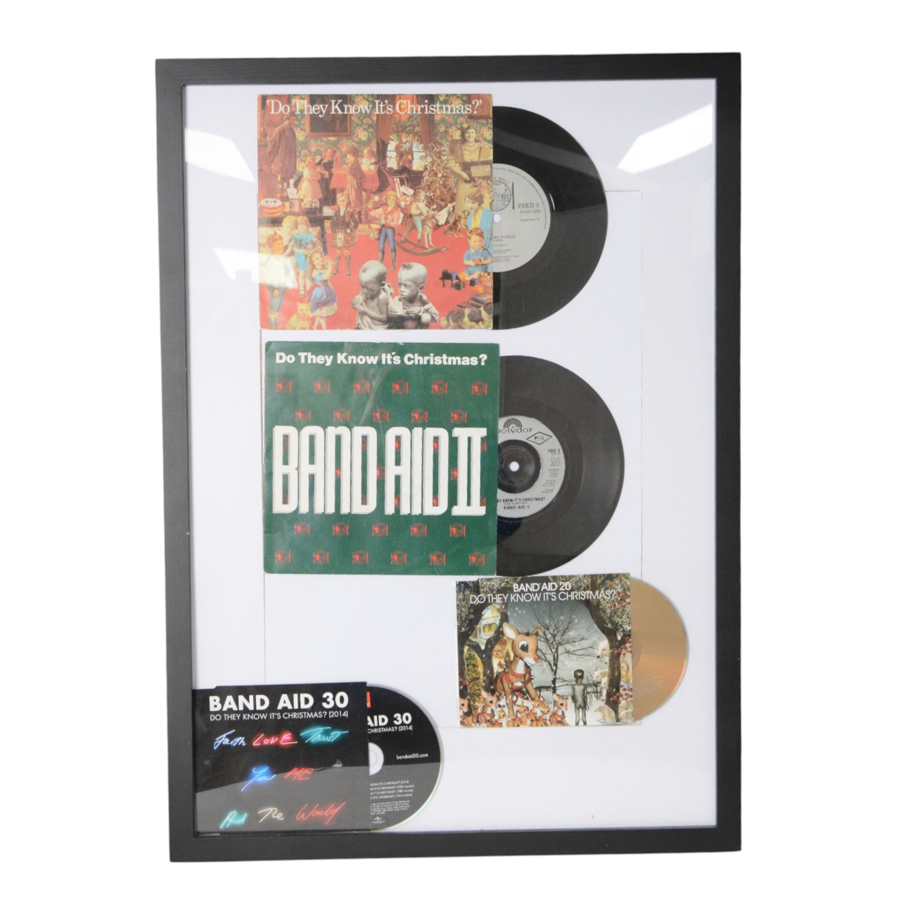 Band Aid vinyls and CDs in framed display, including original Do They Know Its Christmas? and later editions Band Aid II, Band Aid 20 and Band Aid 30, together with limited edition 40th anniversary edition Feed The World 12