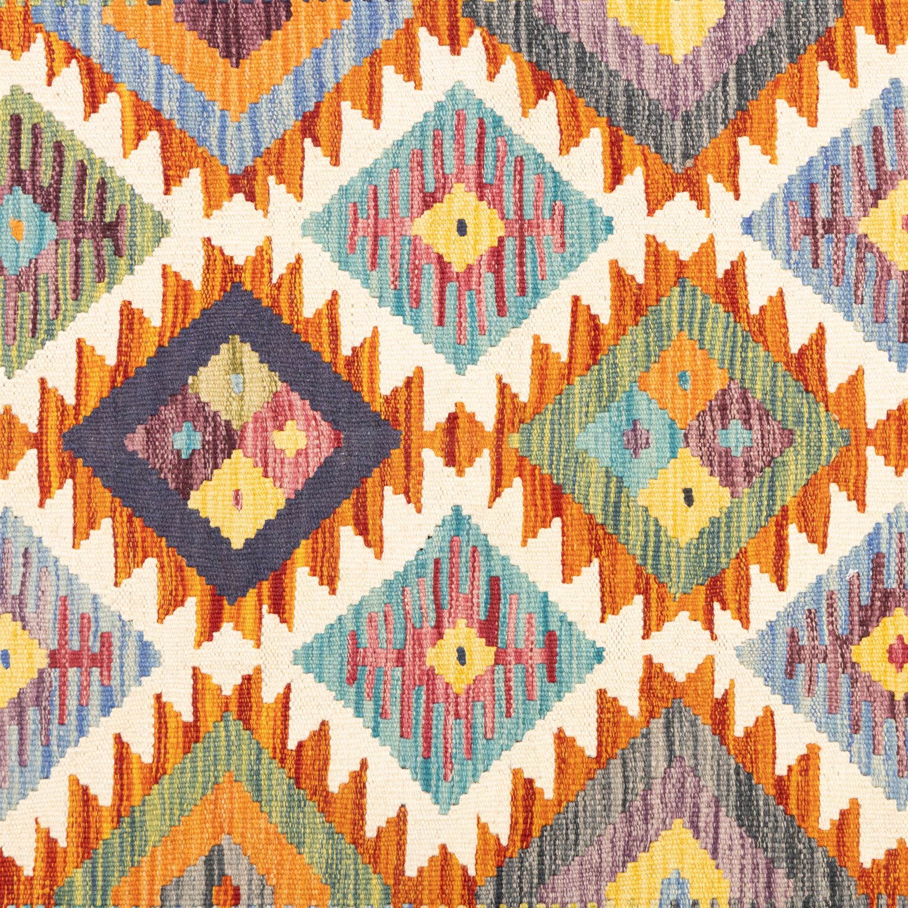Afghan Chobi flatweave kilim with a repeating stepped diamond medallion design in ivory, green, rust, teal, purple, indigo and framed by chevron and geometric borders