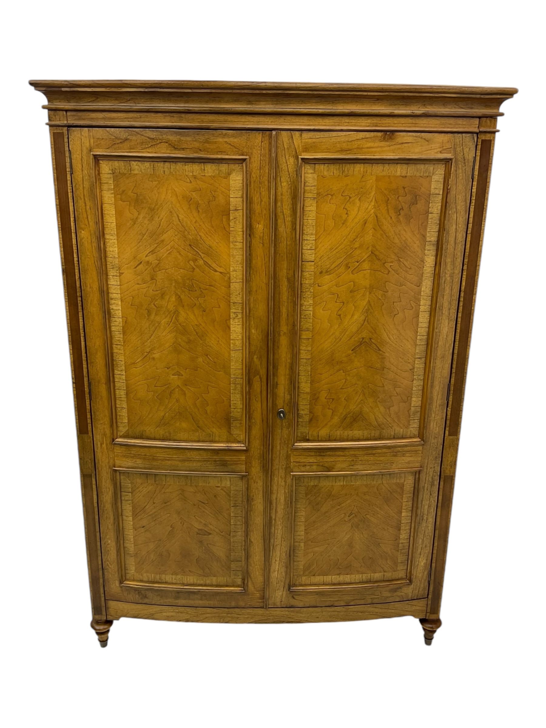 Frank Hudson - mid-20th century Mindi ash and burr walnut double wardrobe, moulded rectangular cornice over two panelled doors with chevron pattern veneers, raised on turned supports