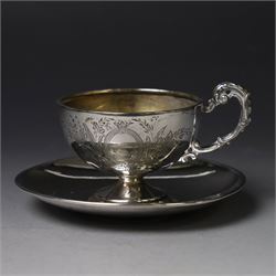 German silver cup and saucer, both with engraved foliate decoration, stamped 800, the sauc...
