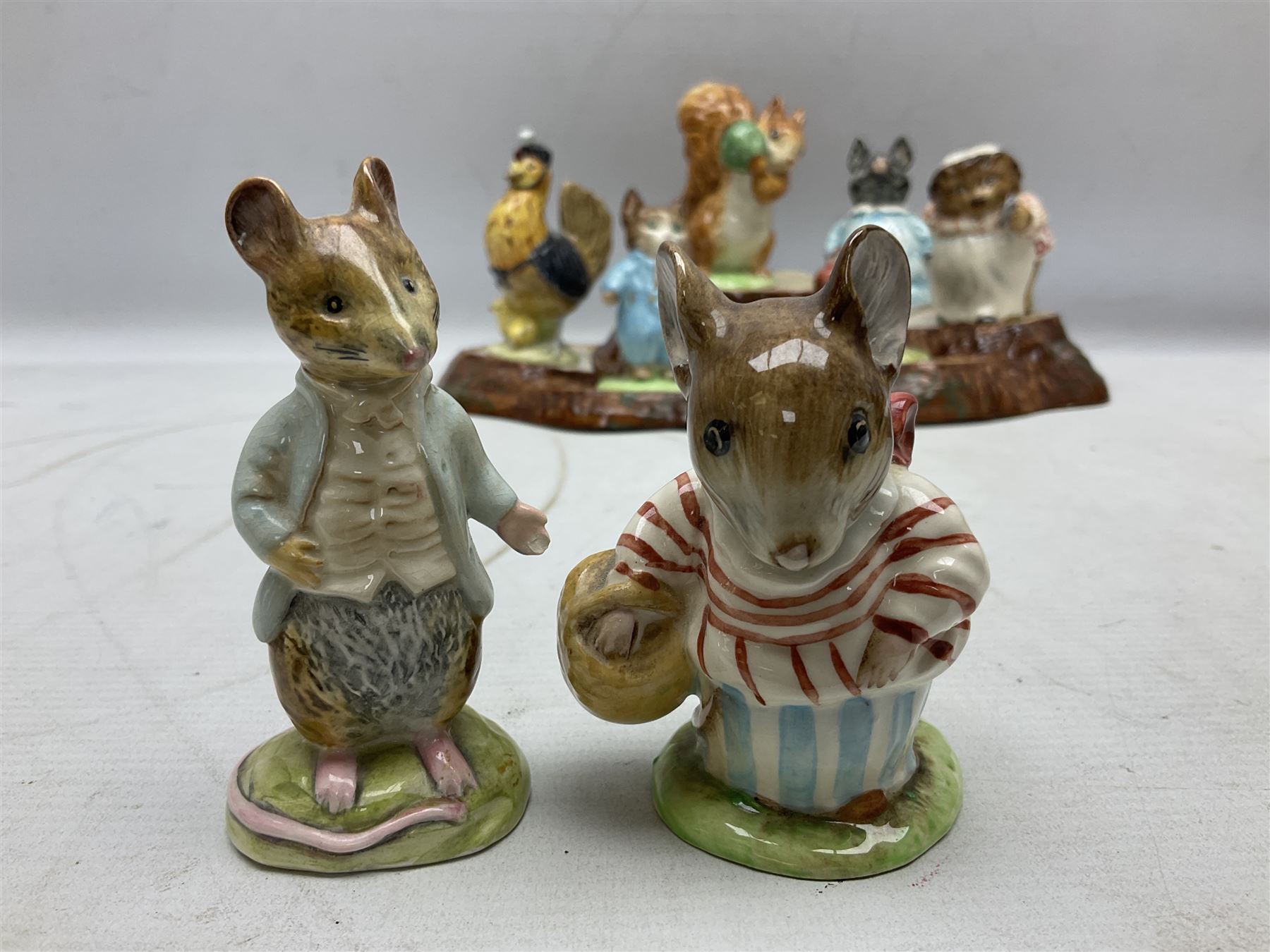 Seven Beswick Beatrix Potter figures, comprising Sally Henny Penny, Johnny Town-Mouse, Mrs Tiggy-Winkle, Mrs Tittlemouse, Tom Kitten, Pig-Wig and Squirrel Nutkin, together with a Beswick tree trunk display stand, stand L30cm