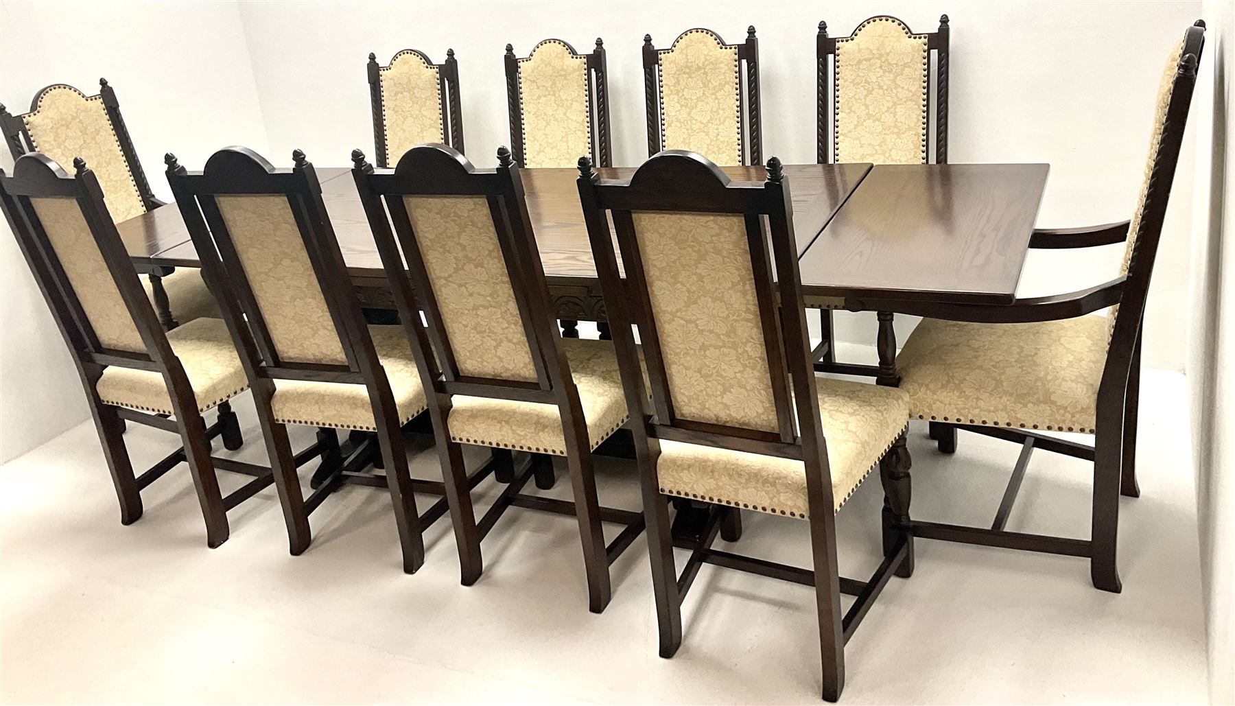 Jacobean style medium oak refectory dining table on cup and cover supports joined by single floor stretcher (W274cm, H77cm, D92cm) and set ten (8+2) high back dining chairs, studded upholstered back and seat, turned supports (W57cm)