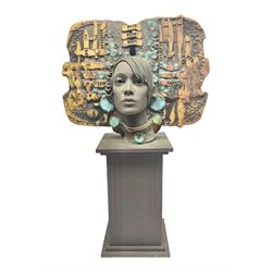 Composite bust, modelled as a woman wearing a headpiece of abstract design, decorated with applied and impressed numbers, letters and shapes, upon a black column plinth, H72cm