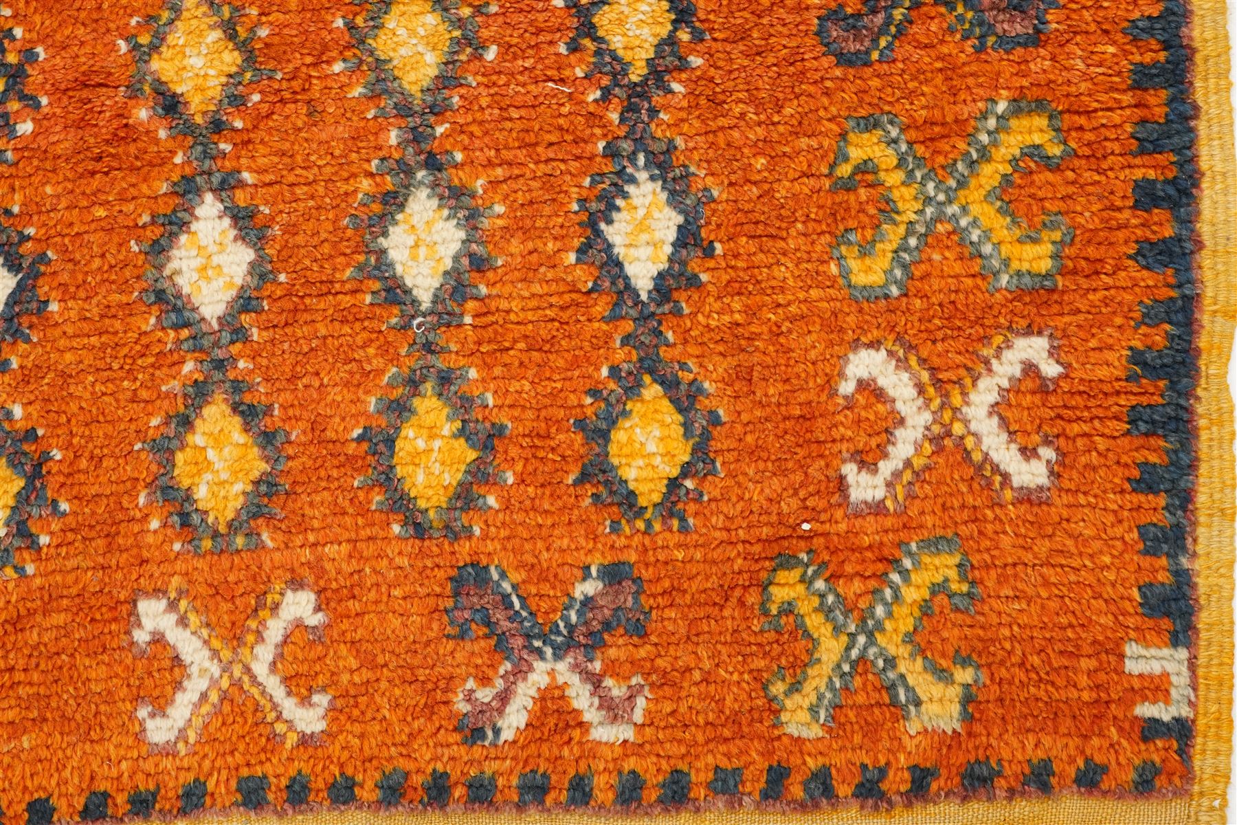North Persian tribal rug, an orange field and six rows of lozenges, with a border of ram's horn motifs