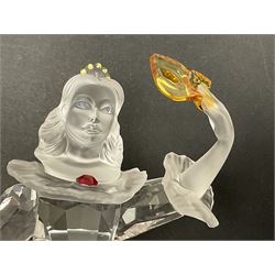 Swarovski Crystal Masquerade trilogy; 1999 Masquerade Pierrot, 2000 Columbine, 2001 Harlequin all with accompanying plaque, stand and original box, together with a glass display case with mirrored back and sides 